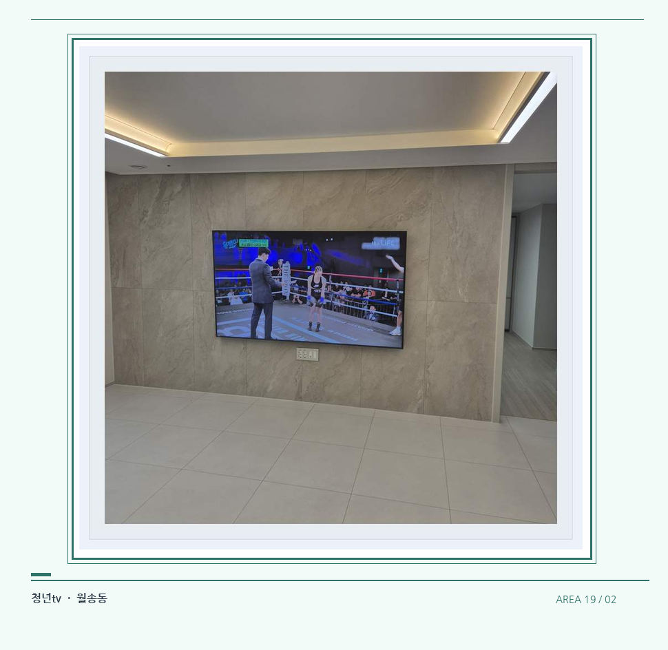 회색 패널 마감과 벽걸이 화면 · 청년tv 벽걸이TV 공간 참고 사진 19-2